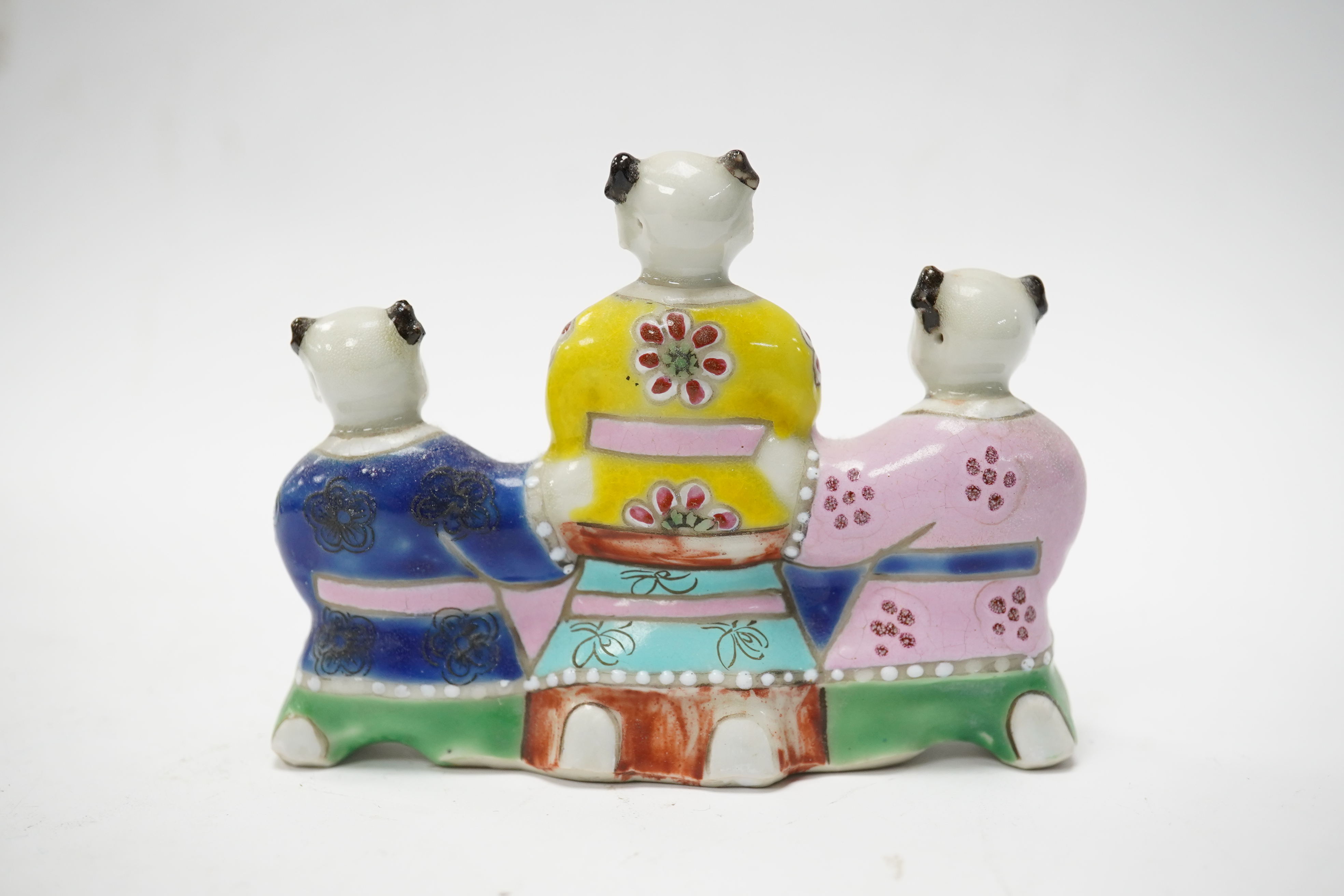 A Chinese enamelled porcelain ‘boys’ brush rest, early 19th century, 10.5cm wide. Condition - fair